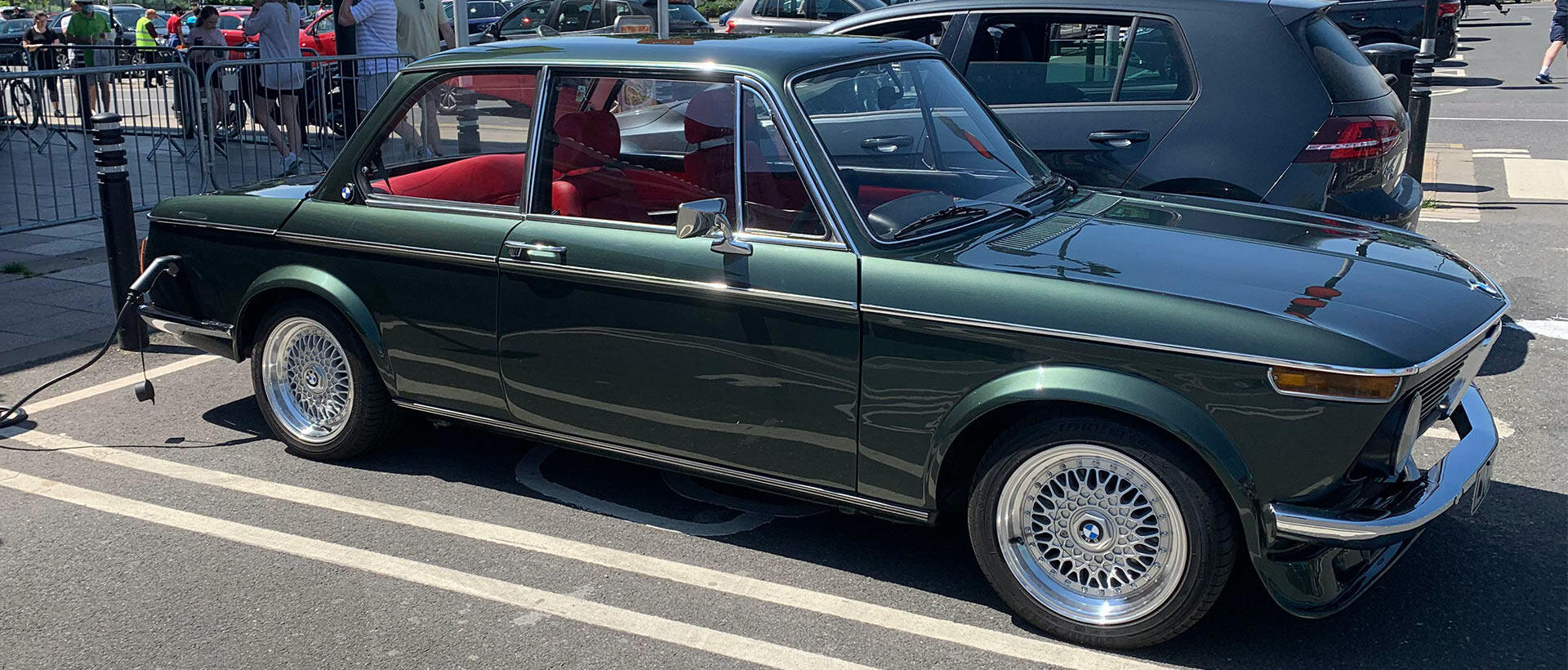 En grön BMW M3 parkerad i en parkeringsplats. (AI text)