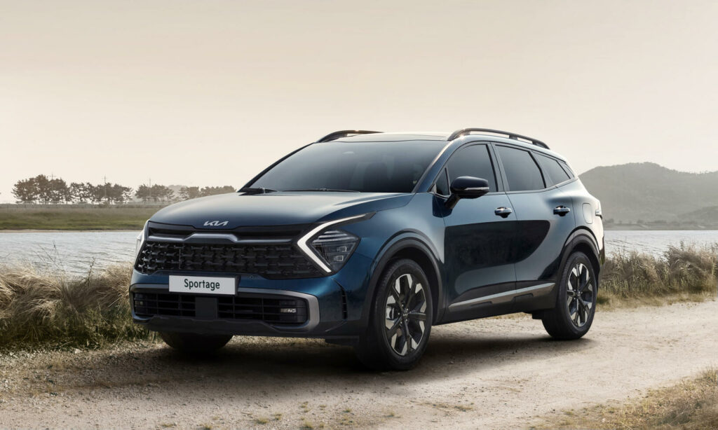 En blå Kia Sportage parkerad på en grusväg vid en sjö. (AI text)