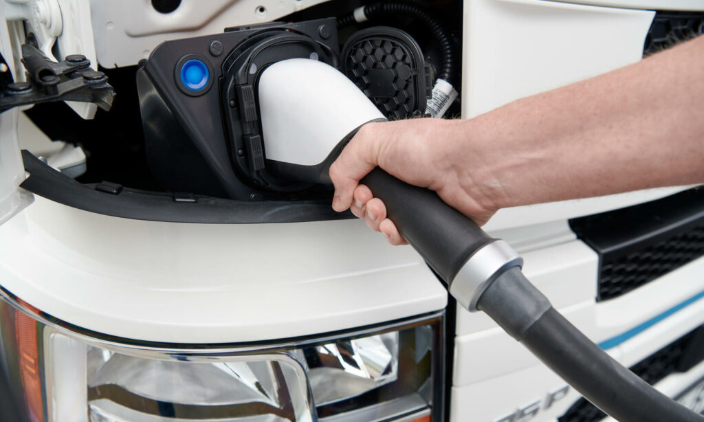 En person laddar en elbil. (AI text)