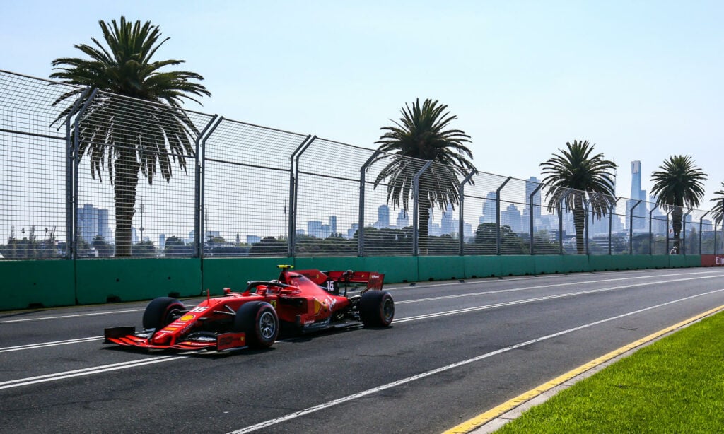 En röd Ferrari F1-bil kör nerför banan. (AI text)