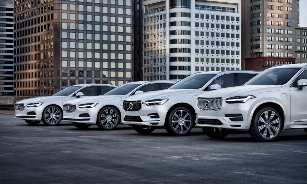 Volvo XC90-suvernående står parkerade framför en stad. (AI text)