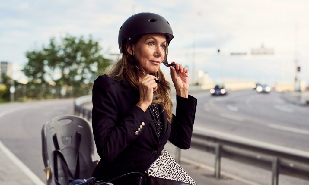 En kvinna cyklar på en stadsgata. (AI text)