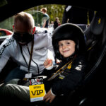 En ung pojke sitter i bilens förarsäte i en sportbil. (AI text)