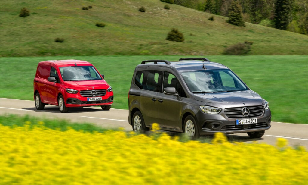 Två Mercedes-Benz-vagnar kör längs en landsväg. (AI text)