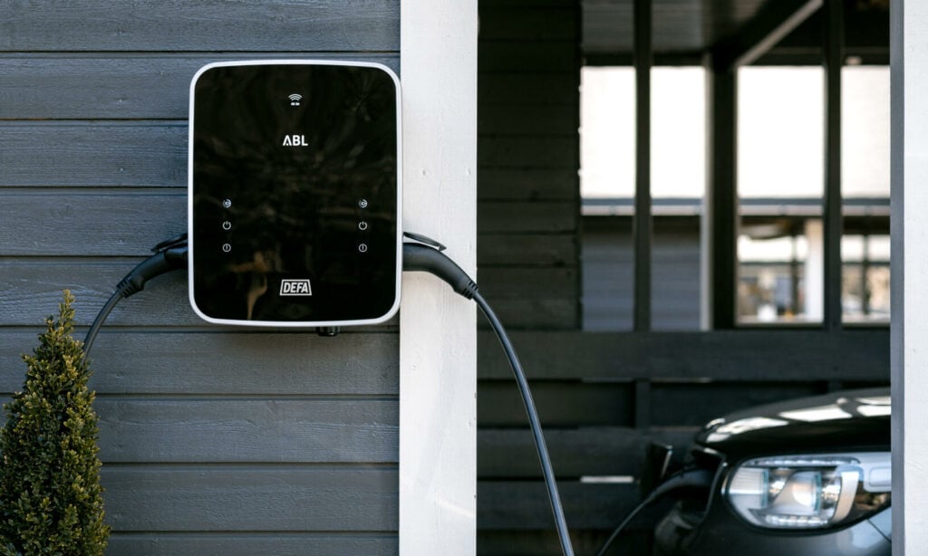 En bil står parkerad framför en hus. (AI text)