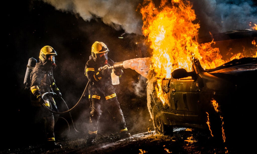 En brandman släcker bilbrand. (AI text)