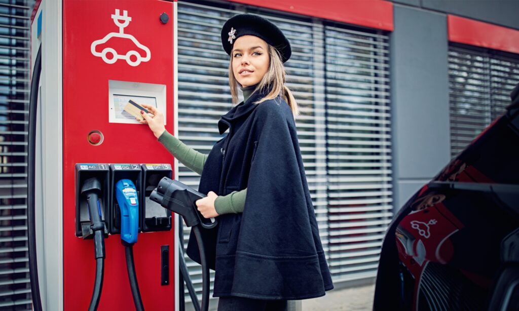 En kvinna fyller på benzinen i sin bil vid en bensinstation. (AI text)