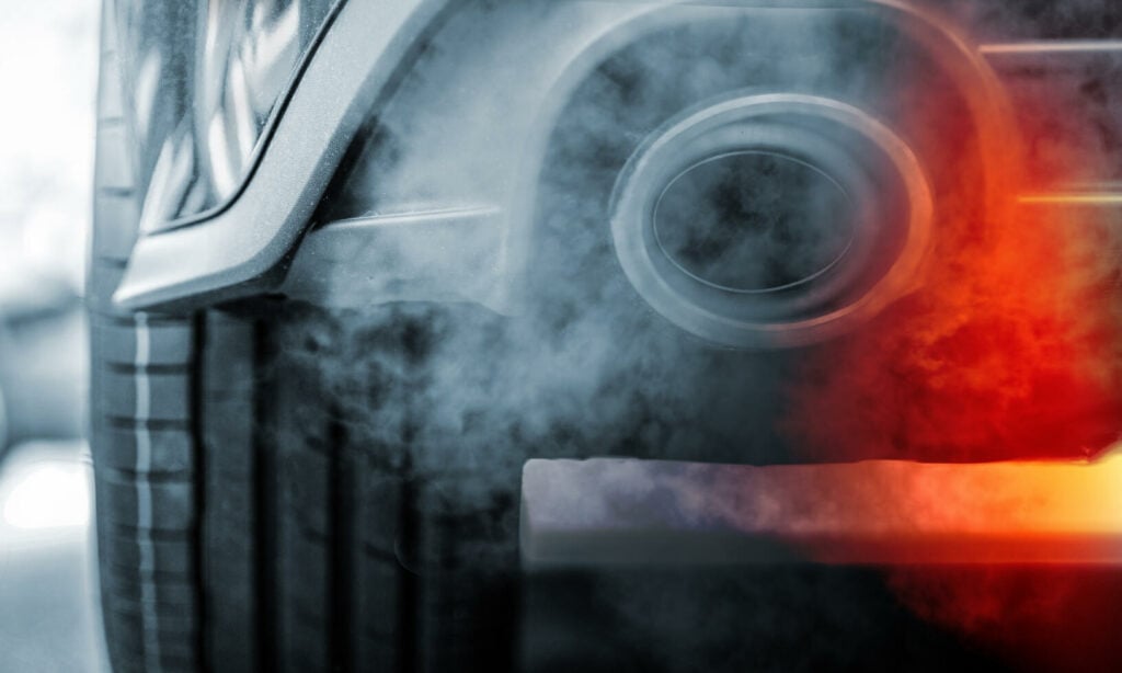 En bil med rök som kommer ut ur dess utluftningsanordning. (AI text)