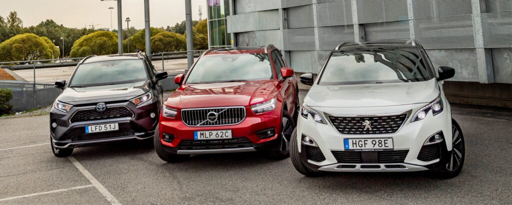 Fyra bilar parkerade framför ett byggnad. (AI text)