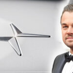 En man i kostym och slips står bredvid en bil. (AI text)