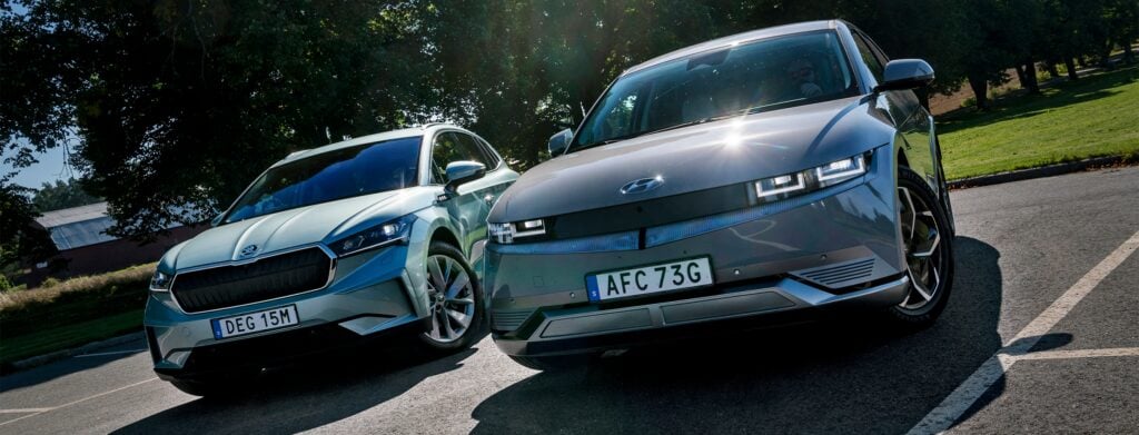 Två bilar står parkerade i en parkeringsplats. (AI text)