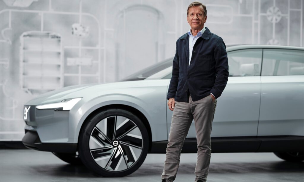 En man står bredvid en Volvo IQ. (AI text)