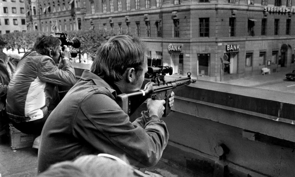 En grupp personer sitter på en bräda och tittar på en bil. (AI text)