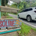 En bil parkerad på en gata i en landsbygd (AI text)