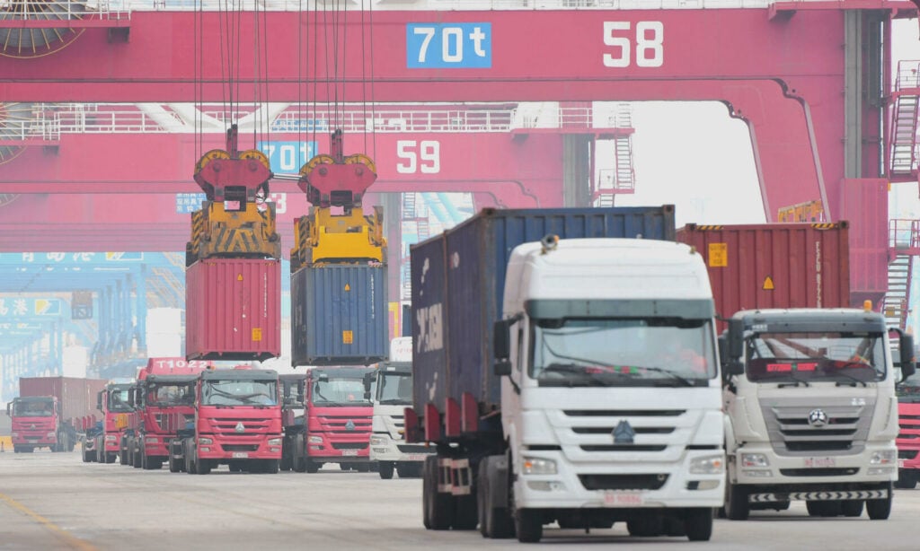 En lastbil kör genom en containerramp i Shanghai. Bild: Reuters. (AI text)