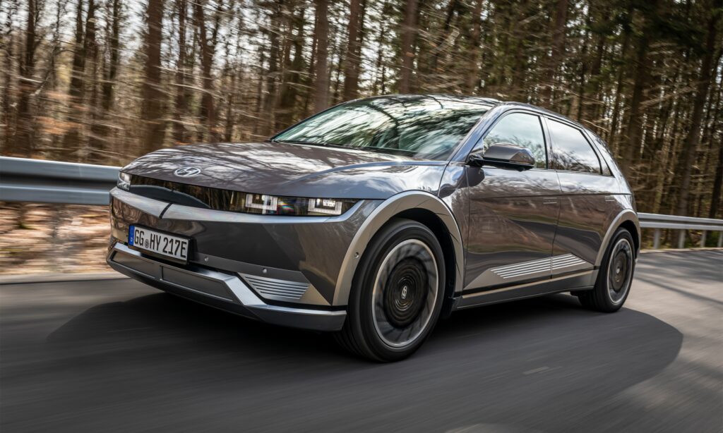 Den nya Audi e-tron kör längs en landsväg. (AI text)