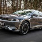 Den nya Audi e-tron kör längs en landsväg. (AI text)