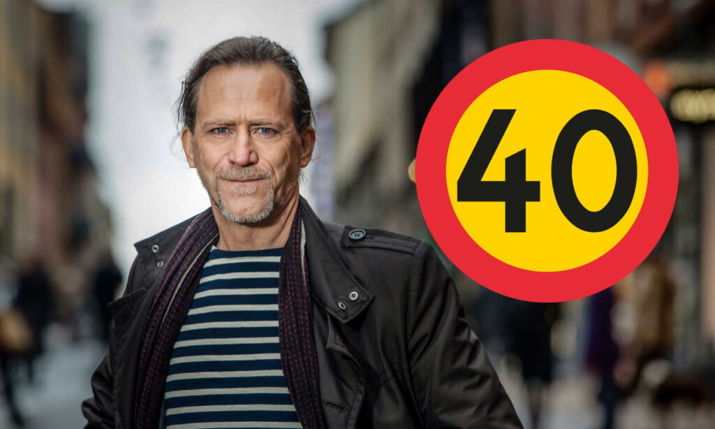 En man i en jacka står på en stadsgata. (AI text)