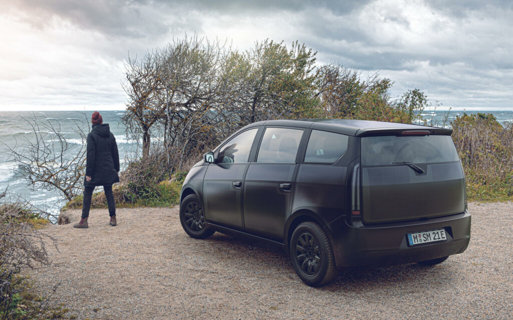 En person står bredvid en bil på en grusväg. (AI text)