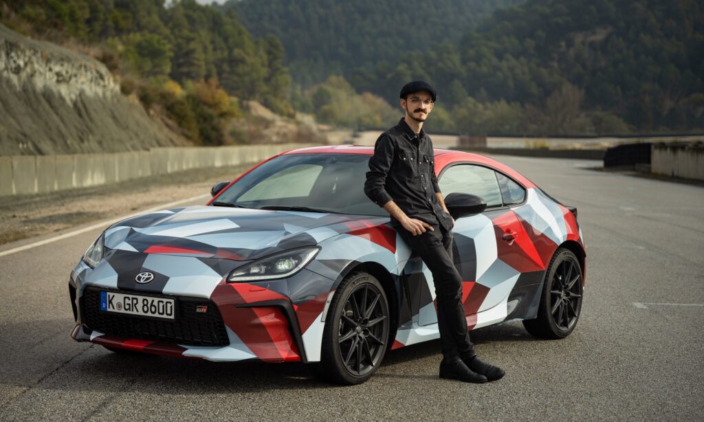 En man står bredvid en Toyota 86 sportbil. (AI text)