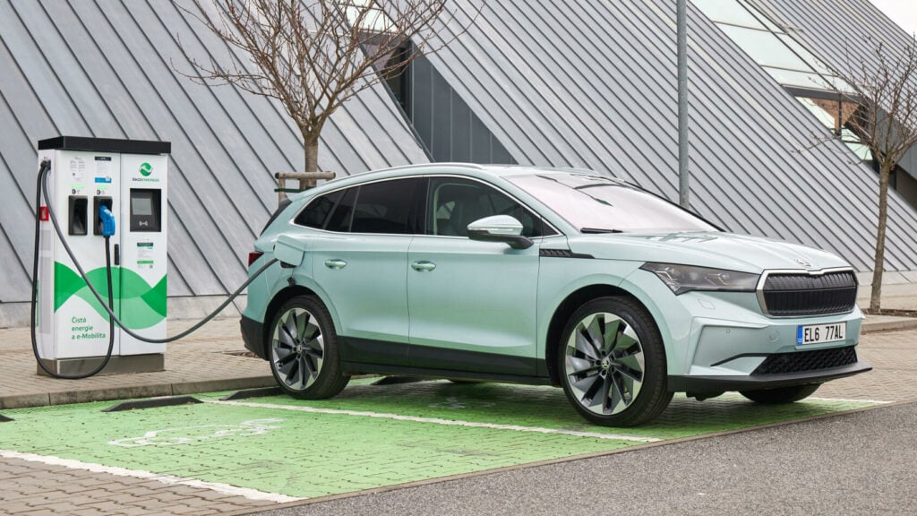 En grön SUV laddar på en elstation. (AI text)