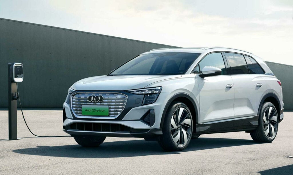 Audi Q3 laddar upp vid en laddstation. (AI text)