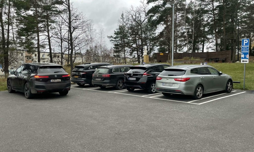 En parkeringsplats med parkerade bilar. (AI text)