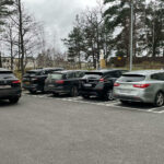 En parkeringsplats med parkerade bilar. (AI text)