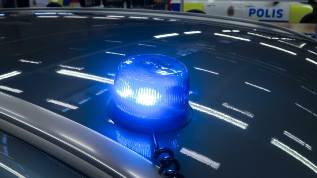 En polisbil med blått ljus på huven. (AI text)