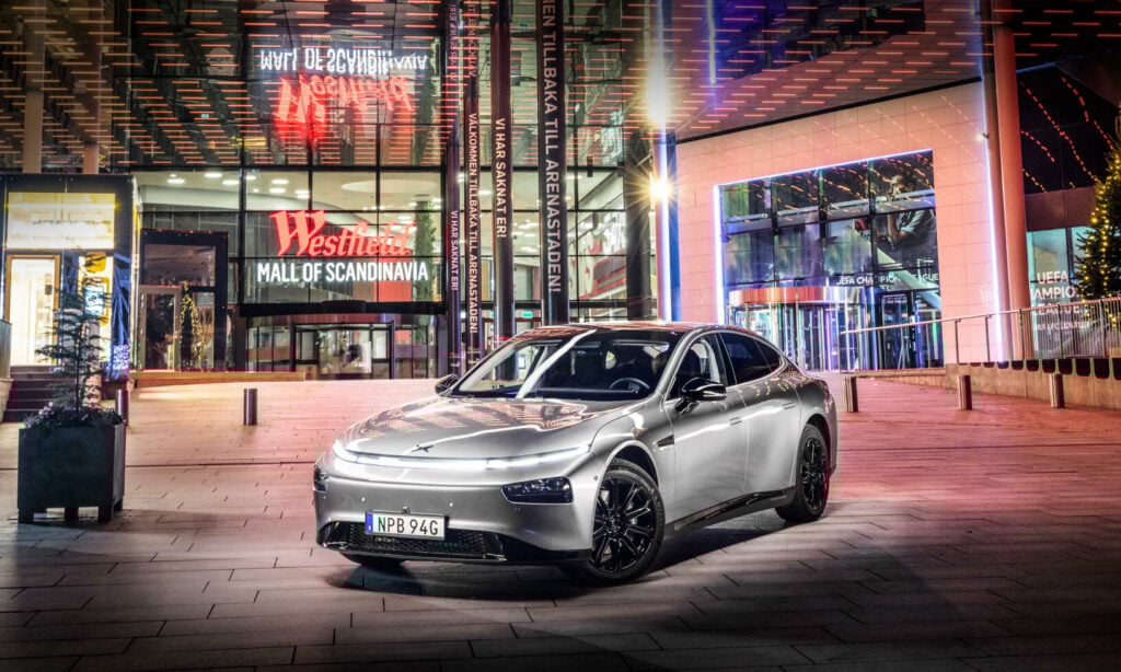 En bil parkerad framför ett byggnad vid nattid. (AI text)