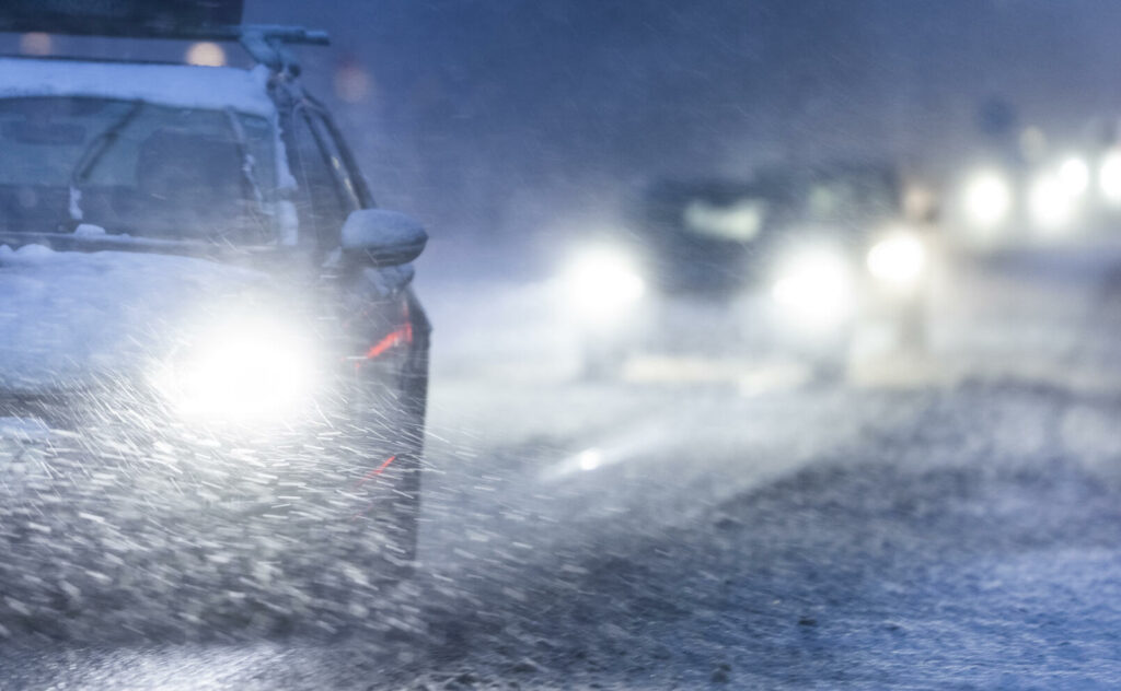 En bil kör på en snöig väg. (AI text)