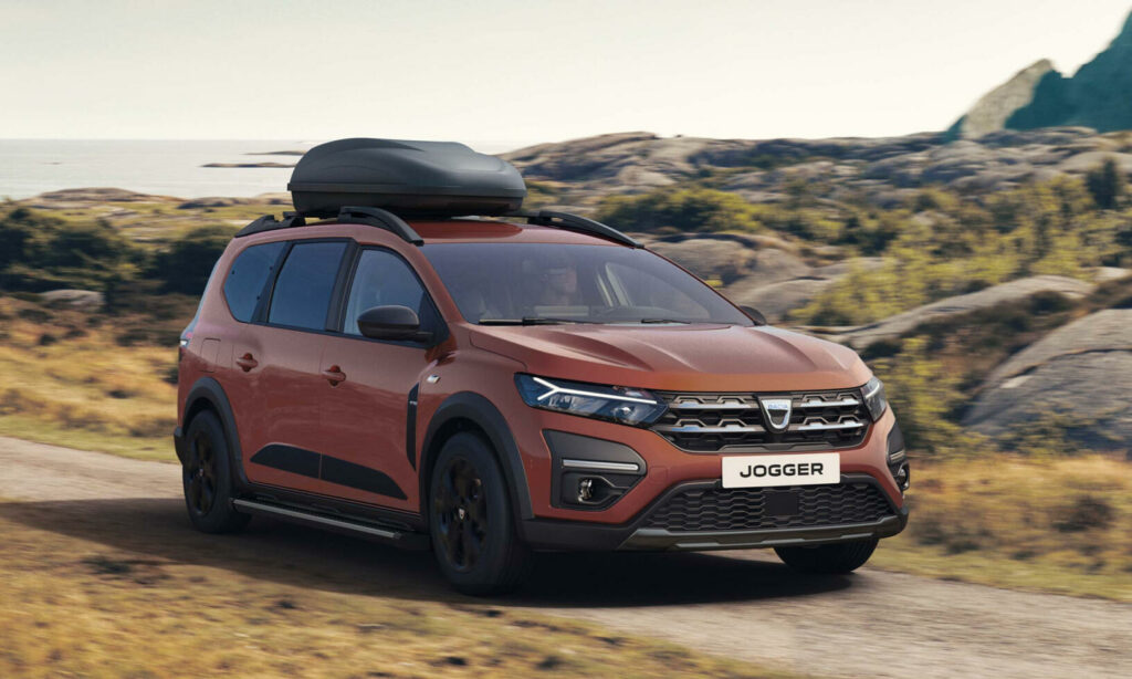 En röd Renault Evoque kör nerför en grusväg. (AI text)