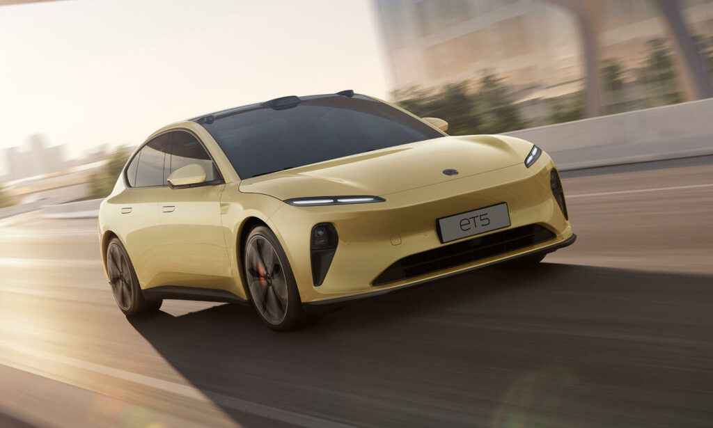 En gul elbil kör genom en stadsgata. (AI text)