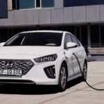 En vit Hyundai Ioniq elbil laddar vid en laddstation. (AI text)