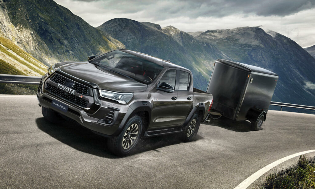 En Toyota Hilux kör nedför en bergsväg. (AI text)