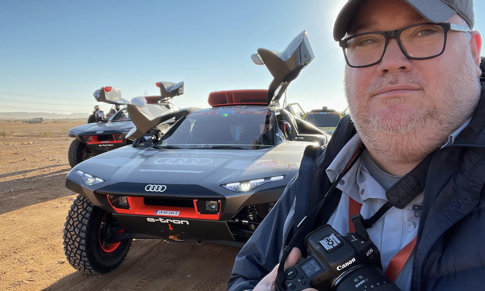 En man tar en bild av en bil och en lastbil. (AI text)