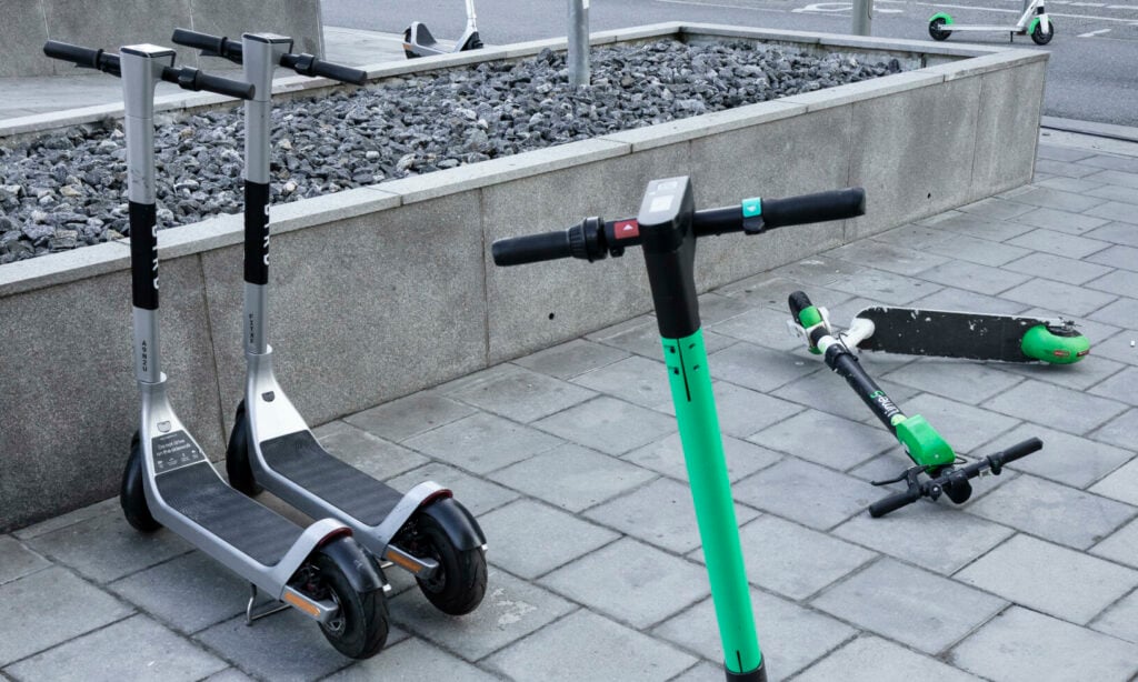 En grupp scootrar parkerade framför en byggnad. (AI text)