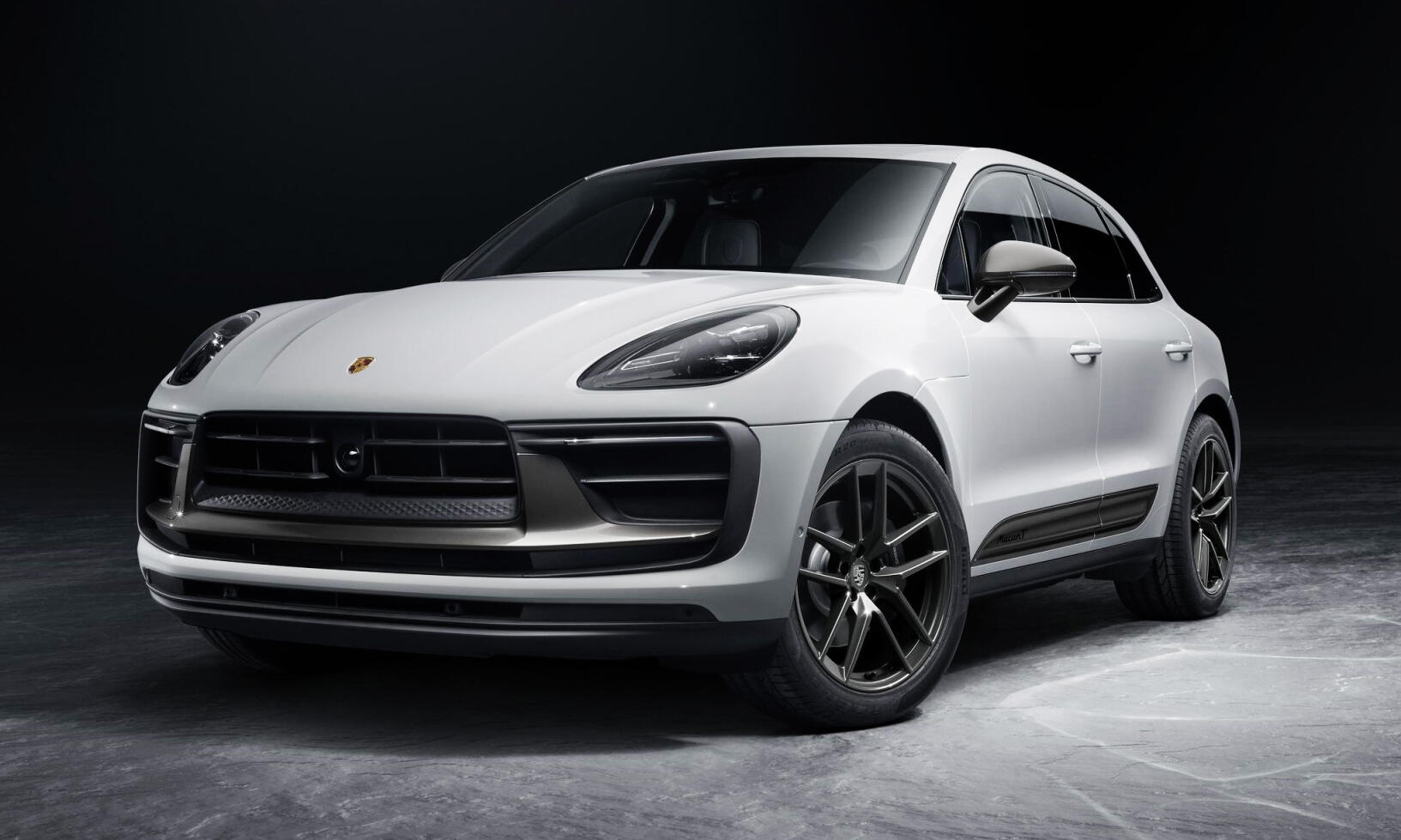 Den nya Porsche Macan visas i en mörk salong. (AI text)