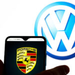 En man håller en smartphone framför Volkswagens logotyp. (AI text)