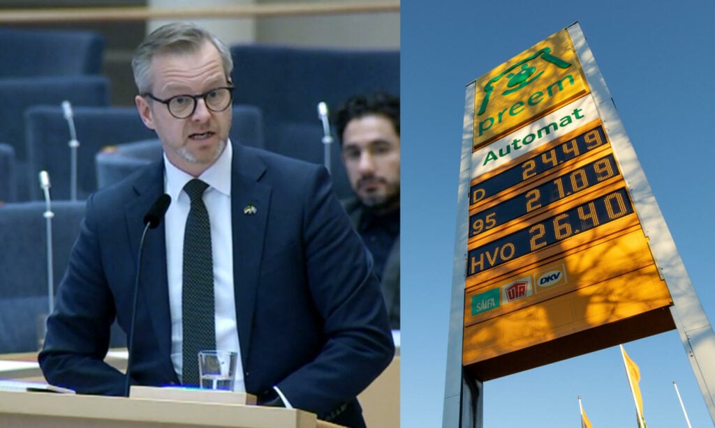 En man står vid ett podiet framför en skylt. (AI text)