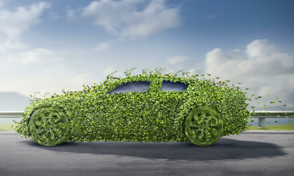 En grön bil med ett träd på sidan. (AI text)