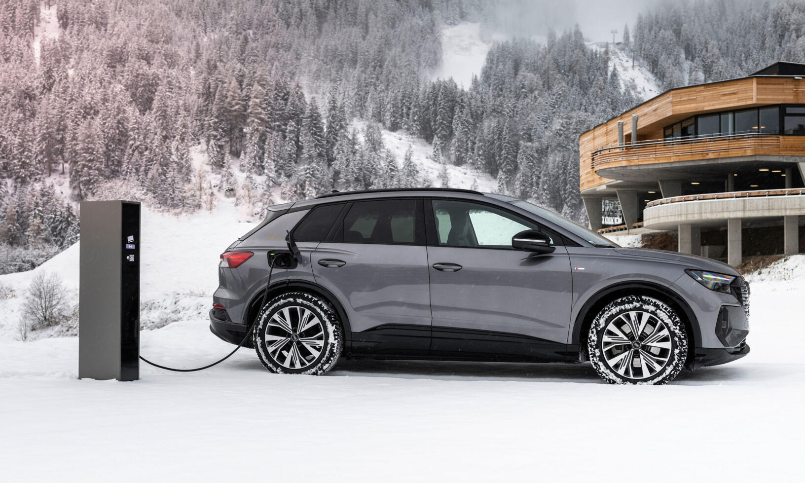 En bil laddar i snön. (AI text)