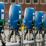 En rad elbilscharger i en parkeringsplats. (AI text)