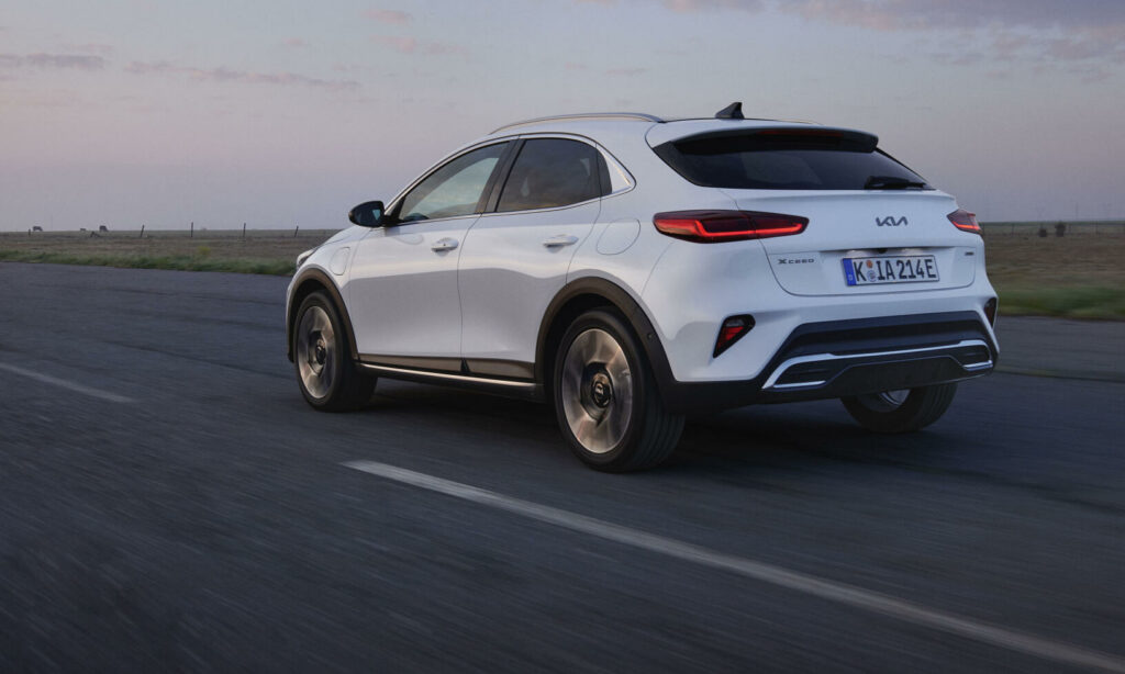 En vit SUV kör ner en väg. (AI text)