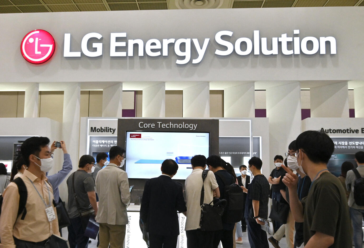 En grupp personer står framför en skylt med texten "LG Energy Solution". (AI text)
