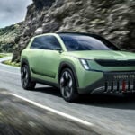 En grön SUV kör nerför en bergsväg. (AI text)