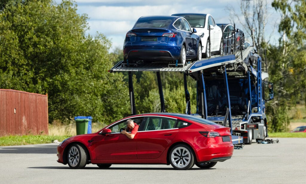 Tesla Model S transporteras av en lastbil. (AI text)