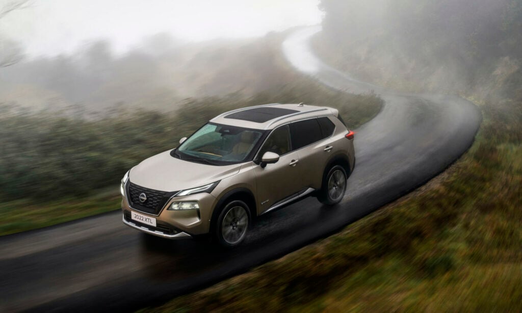 En silverfärgad Nissan Qashqai kör nerför en bergsväg. (AI text)