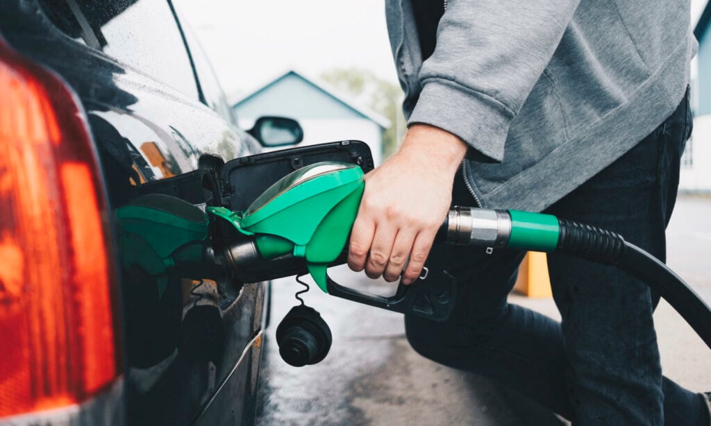 En man tankar upp sin bil med bränsle. (AI text)