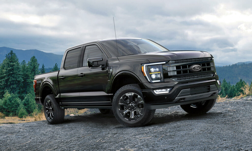 En svart Ford F-150 King Ranch parkerad på en grusväg. (AI text)